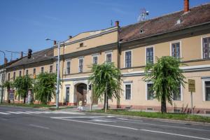a large building with palm trees in front of a street at Körmend lakás in Körmend