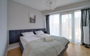 a bedroom with a bed and a large window at Apartamenty EverySky - Wilcza 3F-1 in Karpacz