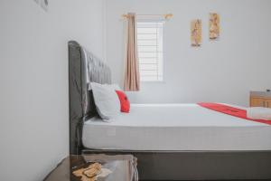 a bedroom with a bed and a window at RedDoorz Syariah near Pahoman Stadium Lampung in Bandar Lampung