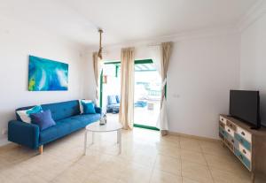 un soggiorno con divano blu e TV di La Siesta Azul a Playa Blanca