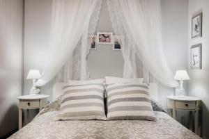 a bedroom with a bed with white curtains and pillows at Carlo Vivari House in Vivari