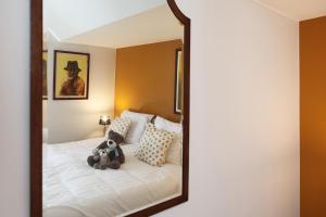 a teddy bear sitting on a bed in a mirror at vakantiehuis-oyenkerke 2 in De Panne