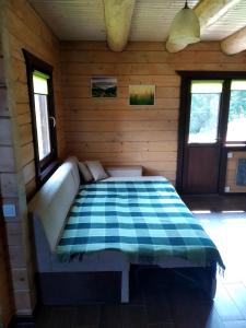 a bedroom with a bed in a wooden cabin at Пагорб Їжака / Hedgehog Hill in Yablunytsya
