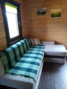 a bed in a wooden room with a window at Пагорб Їжака / Hedgehog Hill in Yablunytsya