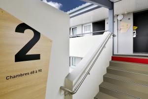 a stairway leading to a building with a sign on it at B&B HOTEL La Rochelle Angoulins in Angoulins-sur-Mer