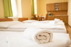 a row of white beds with towels on them at Penzion Burra in Vrútky +31 photos
