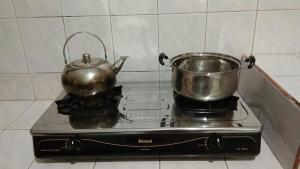 un bollitore per tè e una teiera su un fornello di Homestay Lovebird a Wonosobo