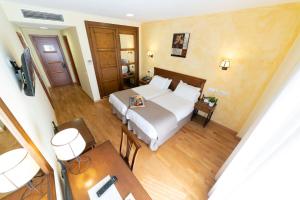- une chambre avec un lit, une table et des chaises dans l'établissement Hotel Comendador, à Carranque