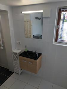 un baño con lavabo y espejo en 2 person Apartment Ascain, en Ascain 13 fotos más