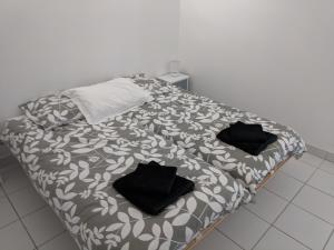 una cama con almohadas negras en una habitación en 2 person Apartment Ascain en Ascain