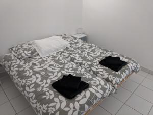una cama con almohadas negras en una habitación en 2 person Apartment Ascain, en Ascain