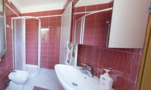 ein Badezimmer mit einem Waschbecken, einem WC und einem Spiegel in der Unterkunft Villa Gabriella in Porto Pino
