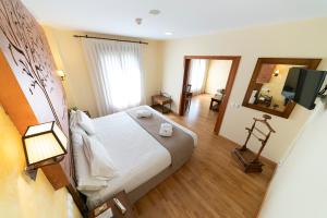 Habitación de hotel con cama y TV en Hotel Comendador en Carranque