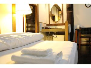 um quarto com duas toalhas brancas numa cama em Kotohira Guest House en em Hita