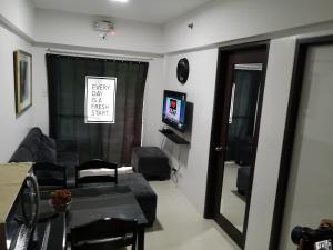 a living room with a couch and a tv and a mirror at Burnham Hill Condominium by KF in Baguio