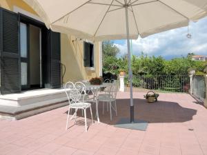 una mesa y sillas bajo una sombrilla en un patio en Villa Sciare Modò, en Acireale