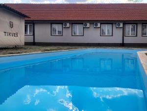 a blue swimming pool in front of a house at Etno Selo Timcevski Complex in Kumanovo