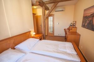 a bedroom with a bed and a dresser at Brezina Pension in Prague