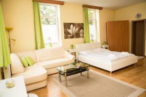 a living room with a white couch and a table at Penzion Burra in Vrútky