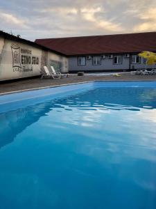 a large blue swimming pool in front of a building at Etno Selo Timcevski Complex in Kumanovo