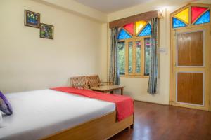 ein Schlafzimmer mit einem Bett und einem Buntglasfenster in der Unterkunft The Wild Trails by Livingstone in Kalpa