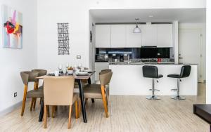 巴拿馬城的住宿－Delightful Apartment City Center - PH Quartier Atlapa，厨房以及带桌椅的用餐室。