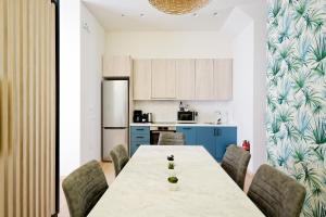 uma cozinha com uma mesa e cadeiras e um frigorífico em Muses Residence em Atenas