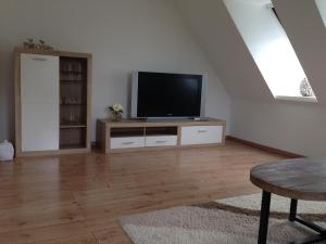 a living room with a flat screen tv on a dresser at Hendreich's Hof in Boitin Resdorf