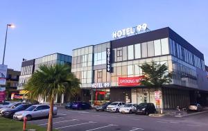 a parking lot with cars parked in front of a building at Hotel 99 Sepang KLIA & KLIA2 in Sepang