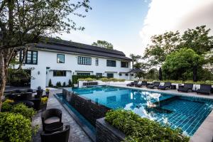 a swimming pool in front of a house at Merchant Villa- SHA Extra Plus in Chiang Mai