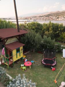 a backyard with a play area with a house at Apartments Boki in Pag