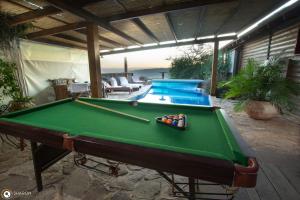 una mesa de billar en un patio trasero con piscina en אניצ'ה en Had Nes