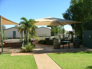 eine Terrasse mit einem Sonnenschirm und einem Tisch in der Unterkunft Discovery Parks - Roxby Downs in Roxby Downs