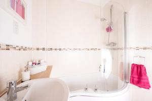 a white bathroom with a tub and a sink at Riverside Stays, Shefford in Shefford