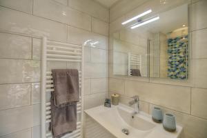 a white bathroom with a sink and a mirror at Le Refuge - Gigaro Lodges in La Croix-Valmer