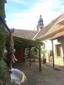 una estatua de una jirafa en un patio con una torre de reloj en Árkádia Apartman, en Pápa