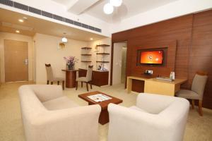 sala de estar con 2 sillas blancas y mesa en Maha Bodhi Hotel.Resort.Convention Centre, en Bodh Gaya