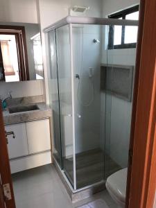 uma casa de banho com uma cabina de duche em vidro e um WC. em Veranno Di Porto-50mts Piscinas Naturais em Porto de Galinhas