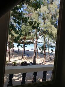 uma vista para a praia a partir de uma janela em Tony Home and Restaurant em Praia de Karon