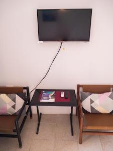 mesa y 2 sillas con TV en la pared en Apartments Boki, en Pag