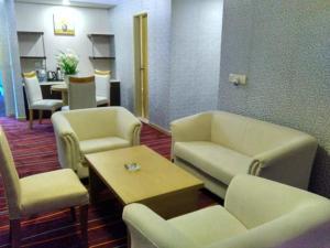 - une salle d'attente avec des canapés, des chaises et une table dans l'établissement Maha Bodhi Hotel.Resort.Convention Centre, à Bodh Gaya