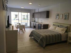 1 dormitorio con 1 cama y cocina con mesa en RM&Asociados en Buenos Aires