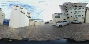 a car parked in a parking lot next to a building at Hotel Minas in Três Marias