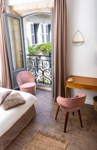- une chambre avec un lit, un bureau et un balcon dans l'établissement Les chambres de l'ATELIER à Montignac Lascaux, à Montignac