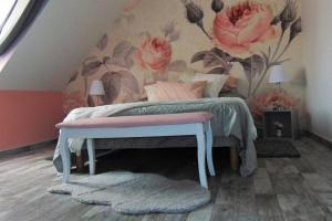 - une chambre avec un lit orné d'un mur fleuri dans l'établissement CHEZ MARIA ET JOSE, à Coucy-le-Château-Auffrique