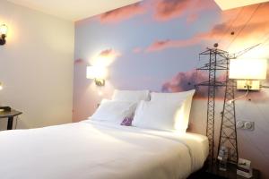 une chambre avec un lit blanc avec un tableau sur le mur dans l'établissement Mercure Paris Malakoff Parc des Expositions, à Malakoff