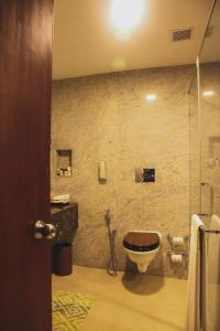 a bathroom with a toilet and a glass shower at Gateway Varkala - IHCL SeleQtions in Varkala