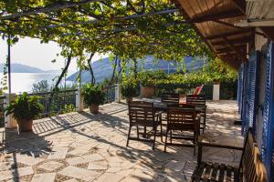 a patio with chairs and a table with a view of the water at Villa Krassi in Ancient Epidauros