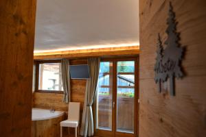 a bathroom with a tub and a sink and a window at Borgo Antico in Sappada +51 photos