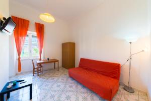 ein Wohnzimmer mit einem roten Sofa und einem Tisch in der Unterkunft A Casa di Mario in Ischia